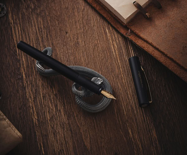 Elegant vintage writing desk with a fountain pen, notebook, and decorative items.